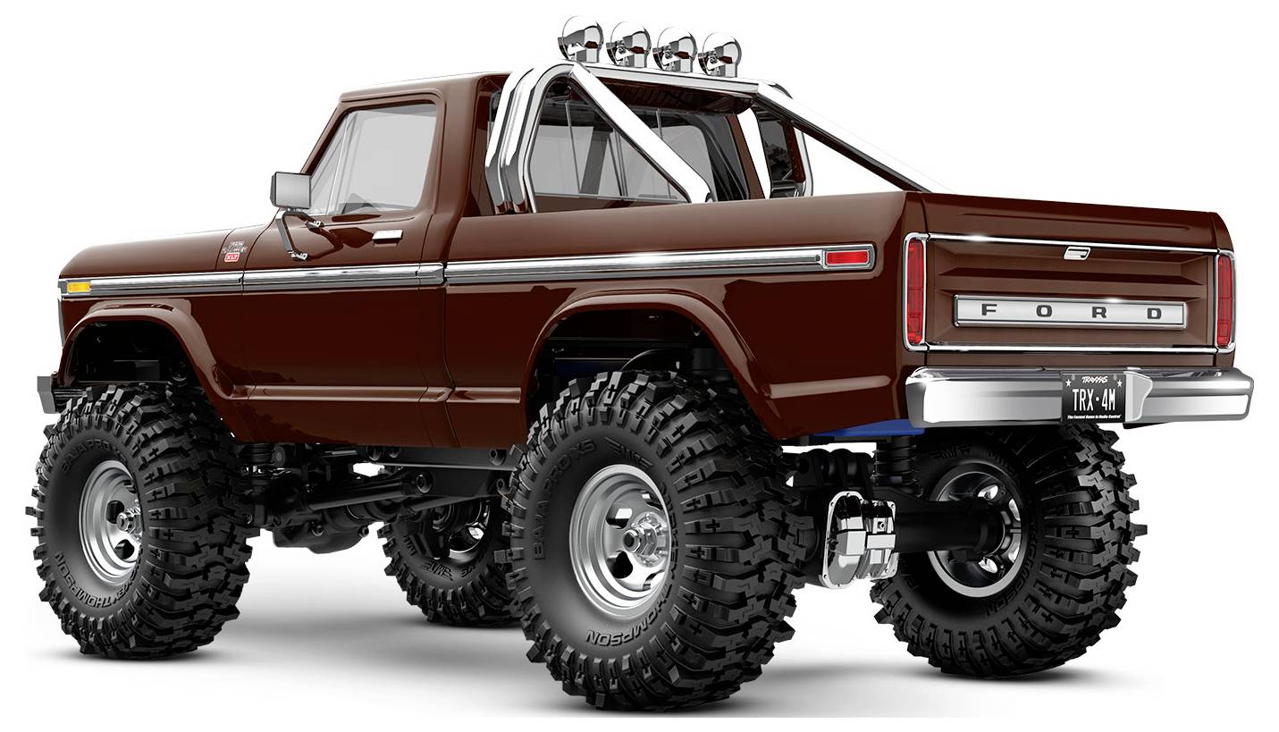 Hnedý vintage pickup truck so zvýšeným podvozkom, hrubými pneumatikami, ochranným rámom a zadnou poznávacou značkou TRX4, pohľad zozadu.