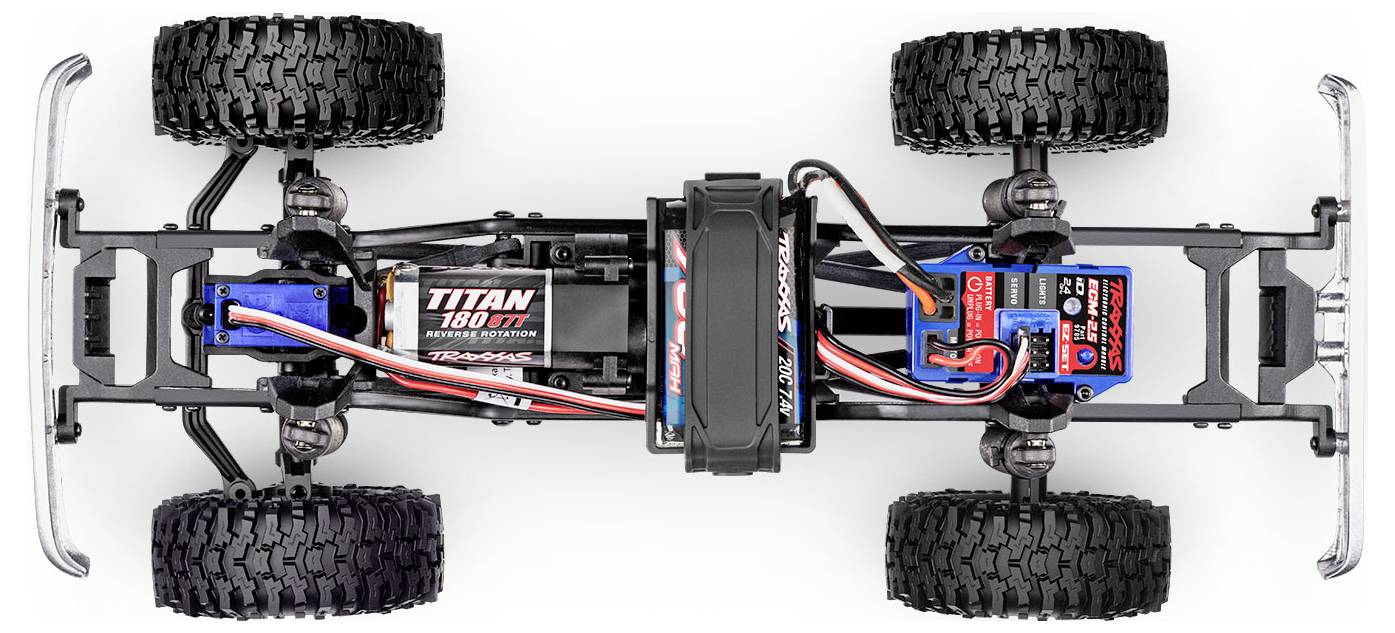 Pohľad zhora na podvozok RC auta so štyrmi veľkými off-road pneumatikami, systémom odpruženia a označenou batériou v strede, prepojenou vodičmi s motorom.