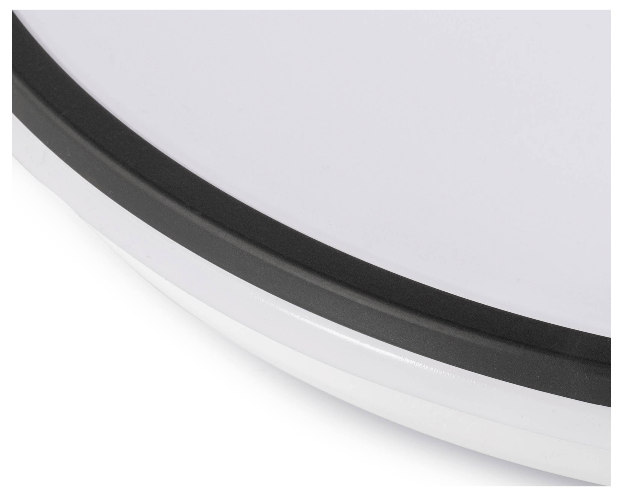 Detailný záber kruhového objektu s bielym povrchom a čiernym okrajom, pravdepodobne súčasť väčšieho predmetu alebo zariadenia. Žiadny text alebo kontext nie je viditeľný.