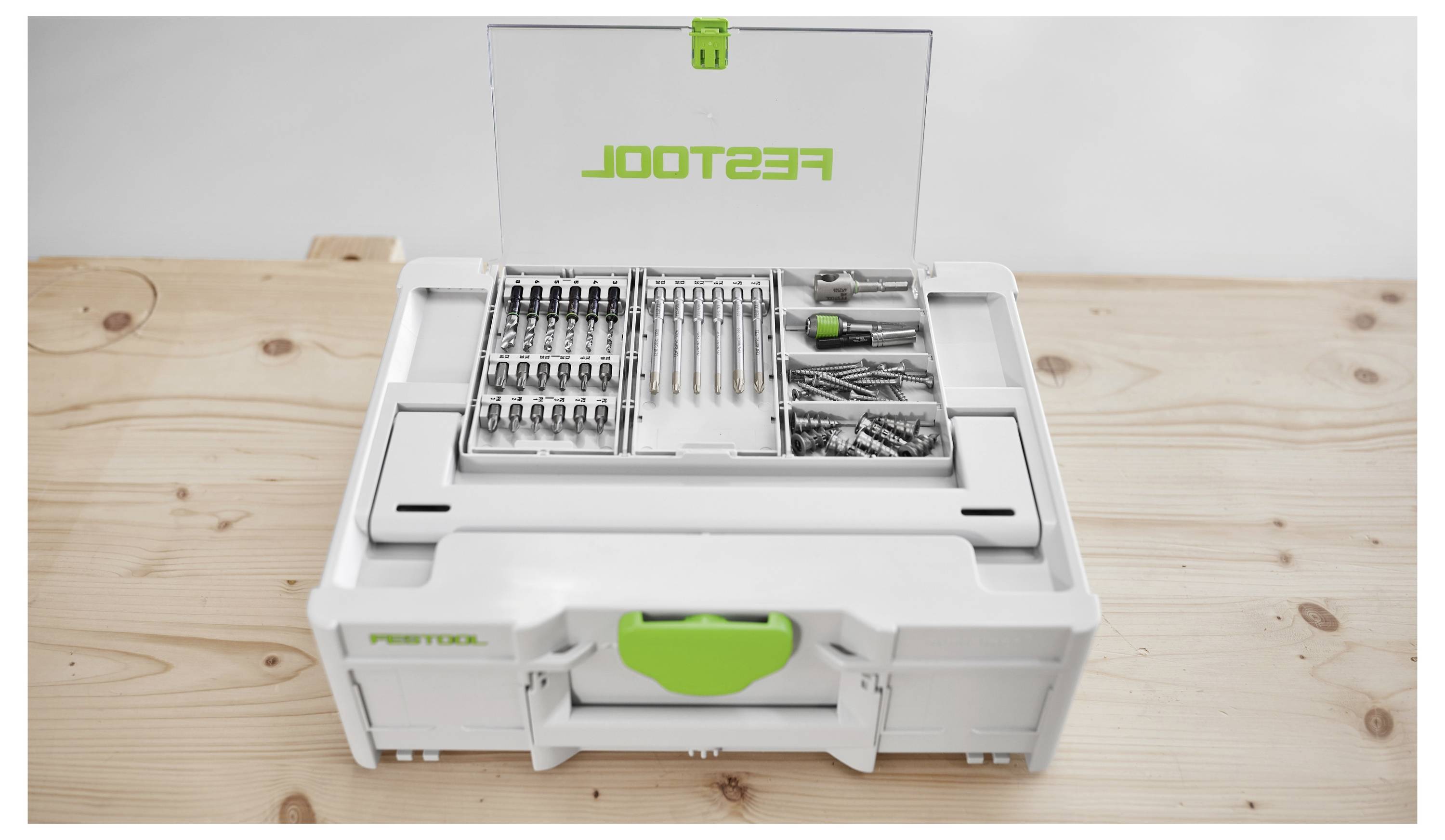 Festool krabička na náradie otvorená na drevenom stole, ktorá ukazuje organizované priehradky s rôznymi vrtákmi, skrutkami a skrutkovačom.