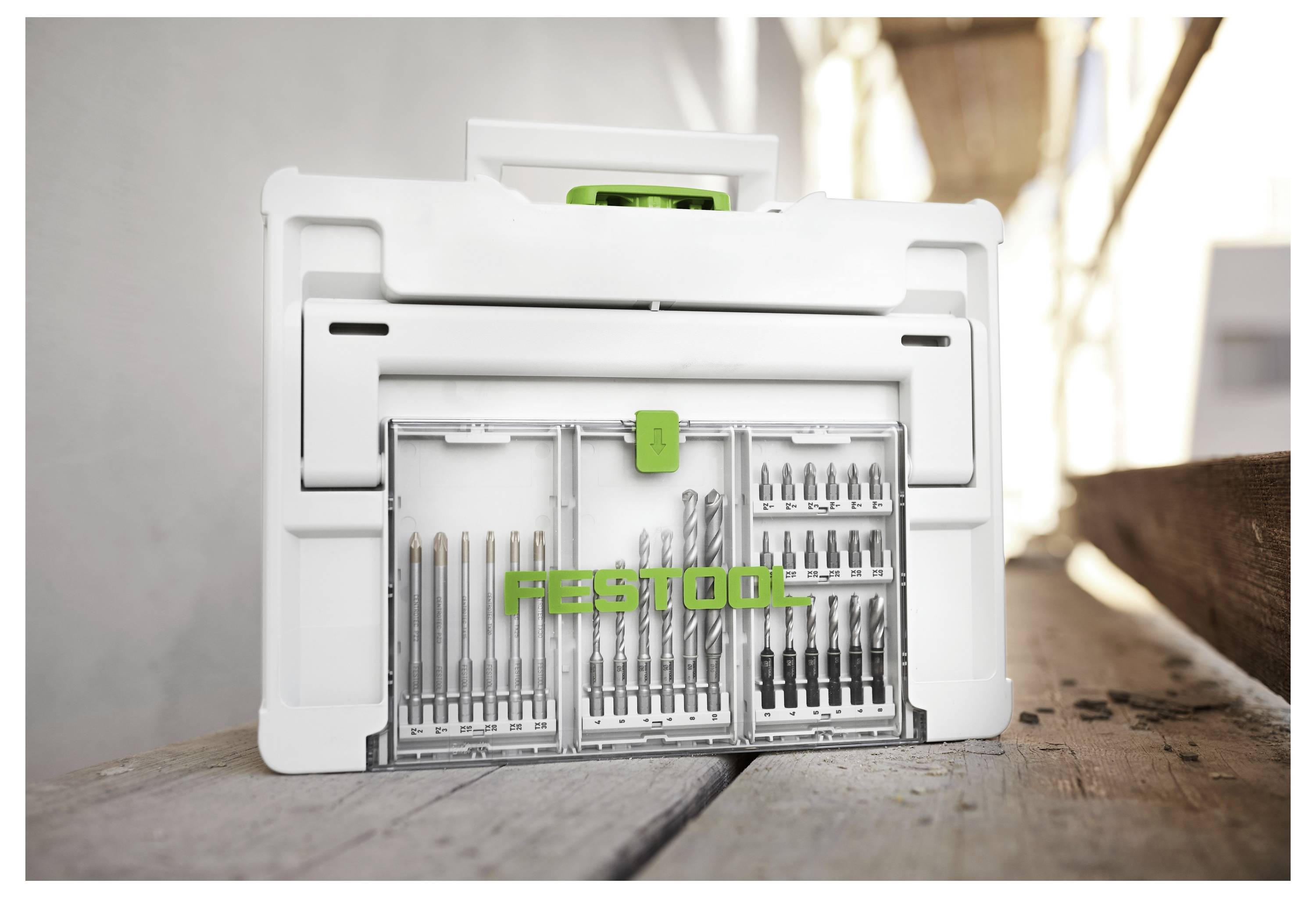 Schránka na uskladňovanie nástrojov s rôznymi vrtákmi úhľadne usporiadanými v radoch, umiestnená na drevenom pracovnom stole s čiastočne osvetleným pozadím.