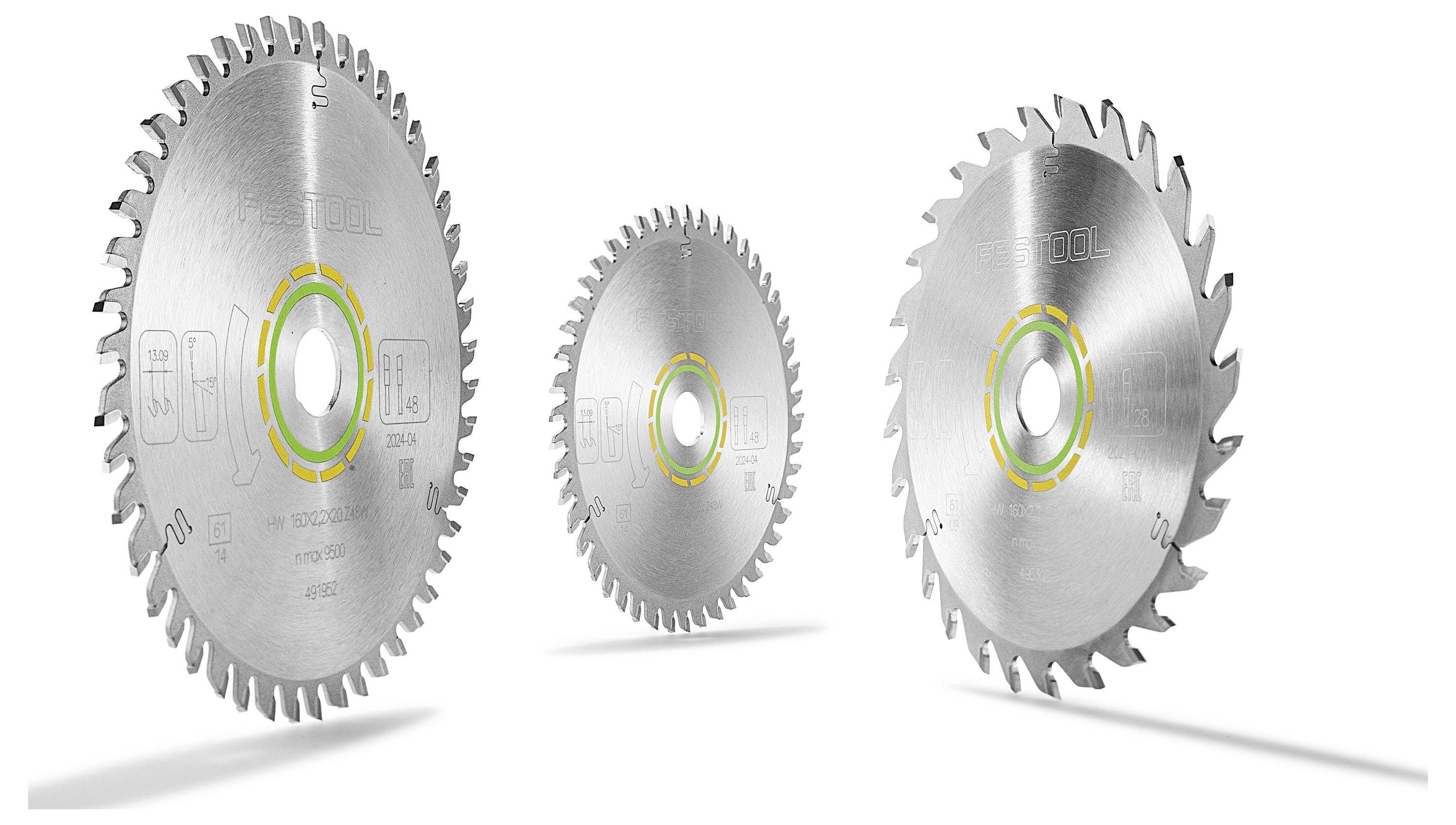 Tri kruhové pílové listy s ostrými zubami, rôznych veľkostí, postavené vzpriamene. Každý list má reflexnú kovovú povrch a farebný štítok blízko stredu.