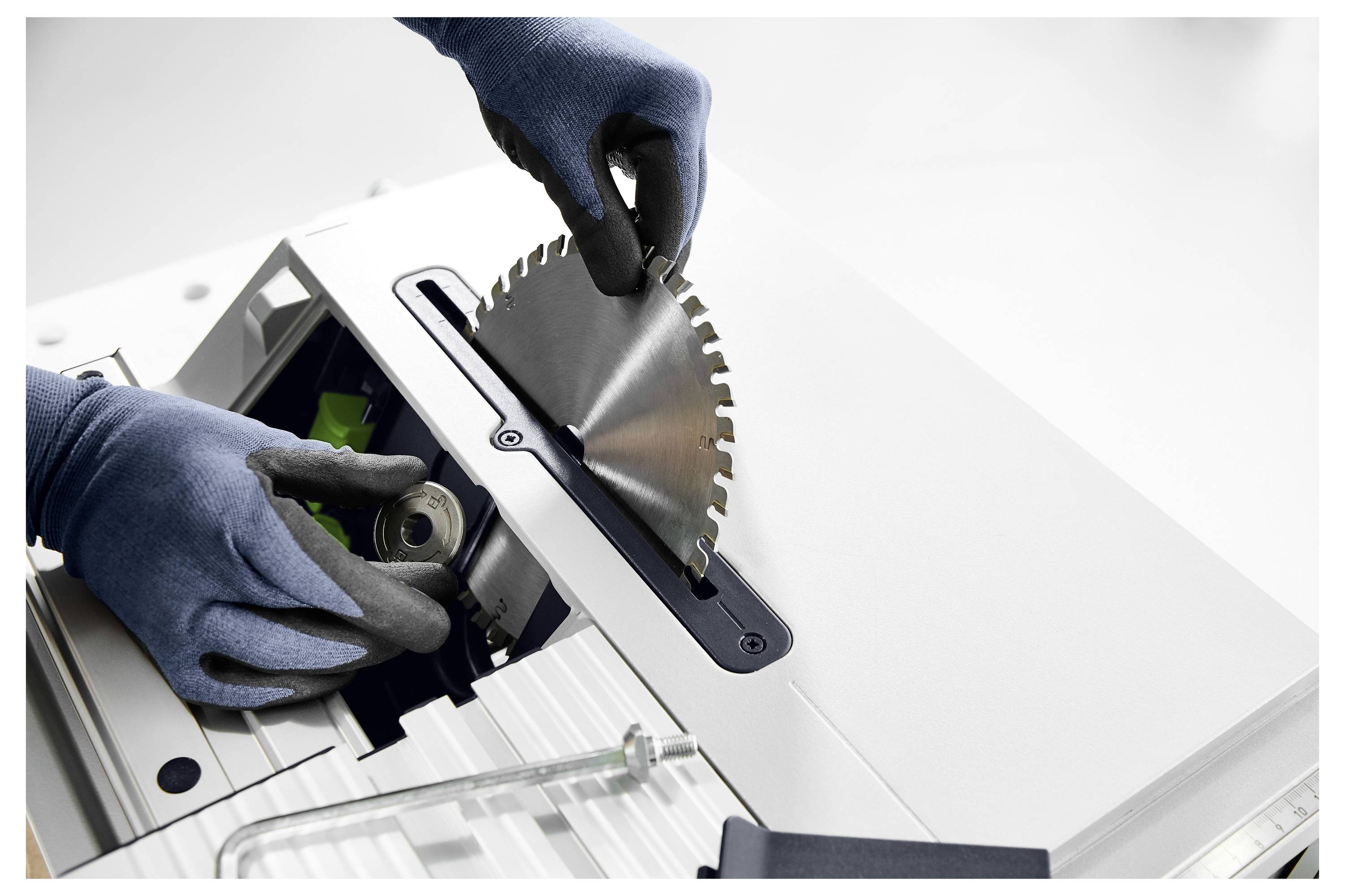 Osoba v rukaviciach starostlivo inštaluje čepeľ kruhovej píly do elektrického nástroja, pričom zdôrazňuje bezpečnosť a presnosť pri manipulácii s nástrojmi.