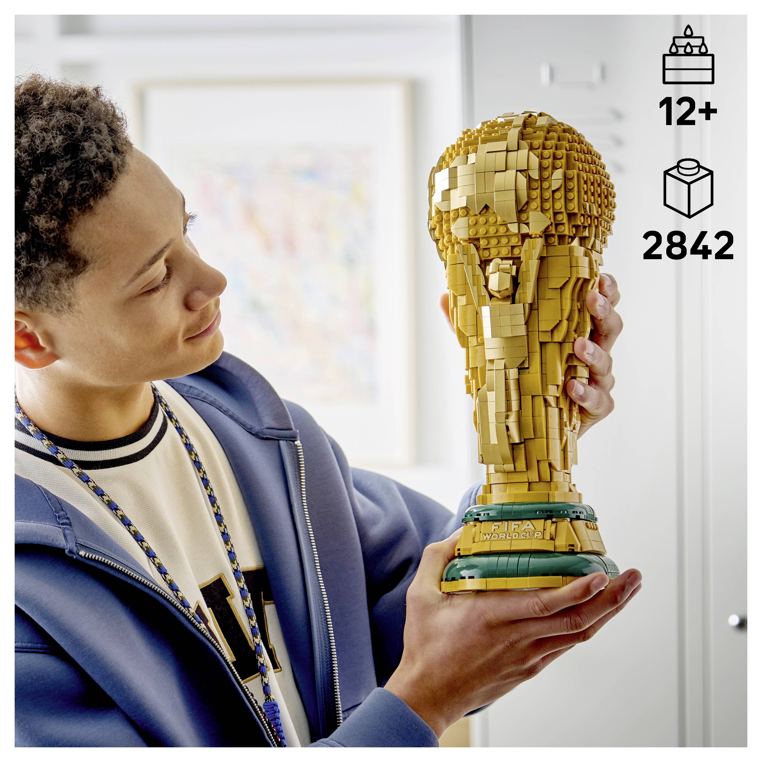 Osoba držiaca detailnú LEGO trofej pripomínajúcu zlatý pohár. Sada je určená pre vek 12+ a obsahuje 2 842 kusov.