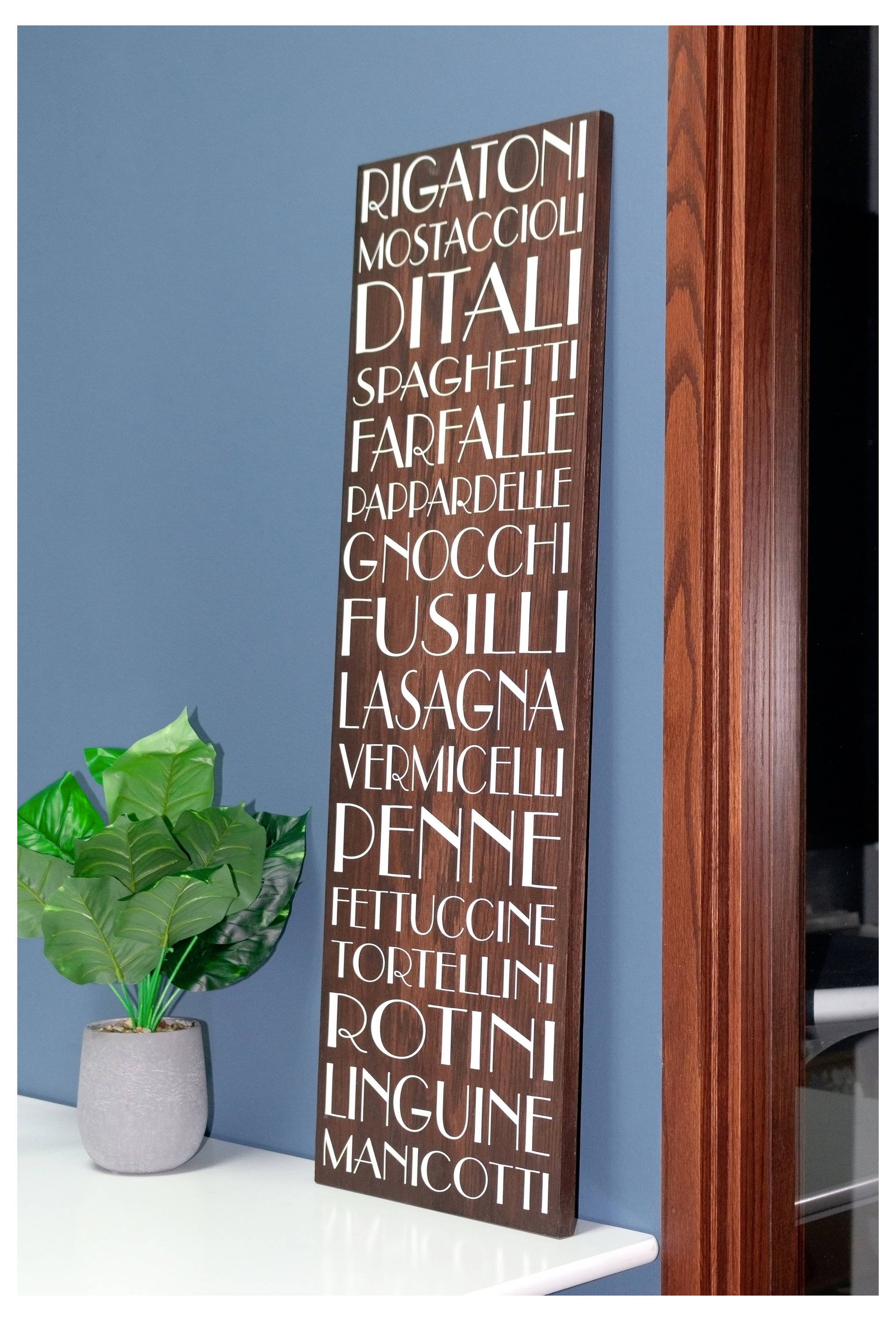 Dekoratívny znak zobrazuje rôzne druhy cestovín, ako sú „Rigatoni", „Spaghetti" a „Linguine", s kvetináčom neďaleko na pracovnej doske.