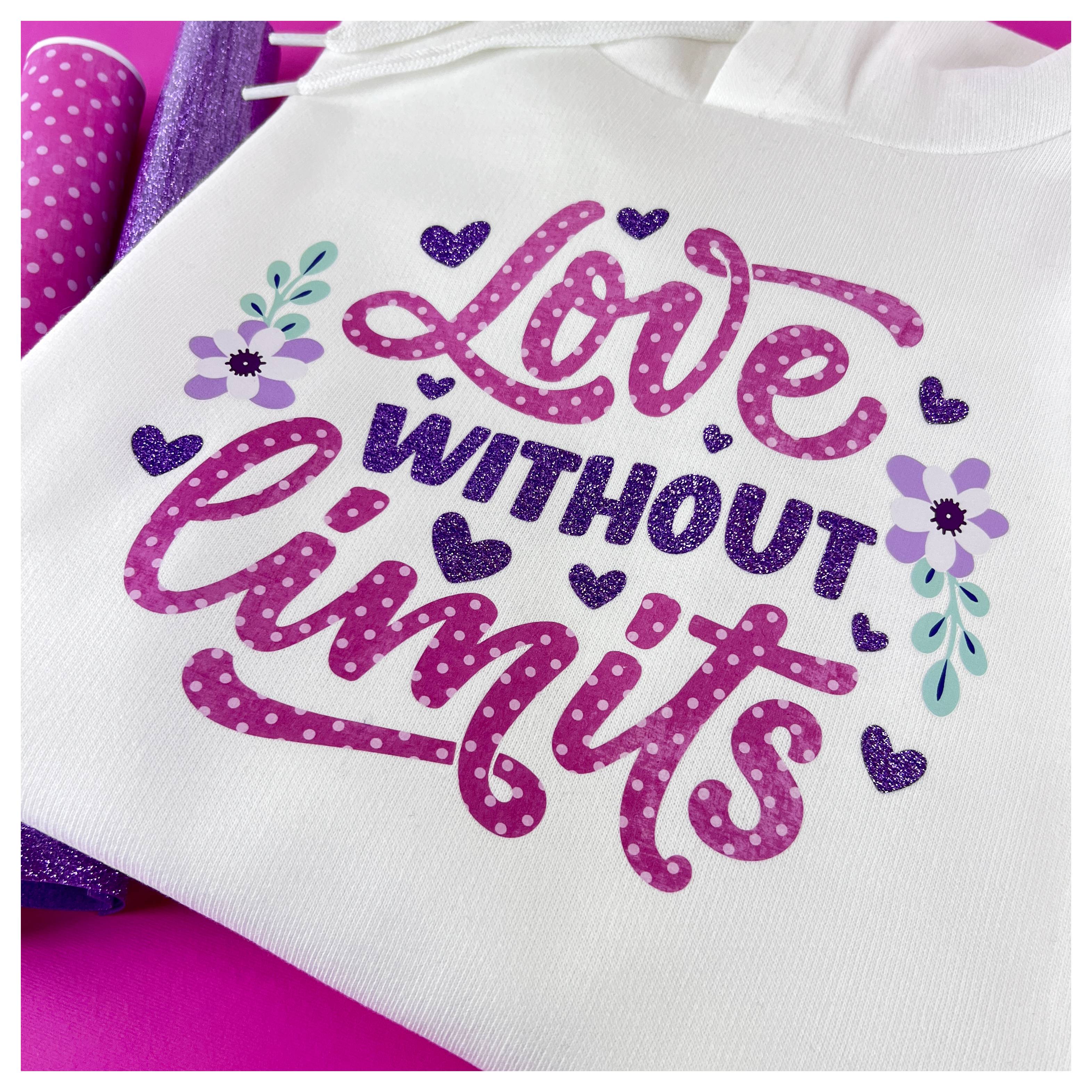 Taška bez rukovätí s textom "Love Without Limits" v ružovej a fialovej farbe s dekoratívnymi srdcami a kvetmi okolo slov.