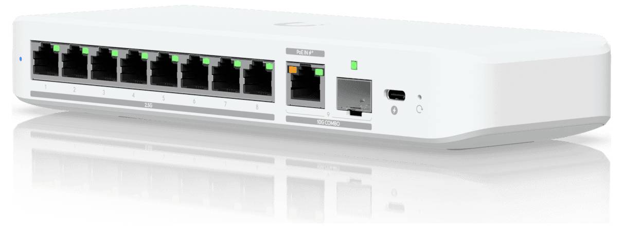 Biely sieťový prepínač s ôsmimi portami Ethernet, jedným portom SFP a portom USB-C, osvetlenými stavovými LED diódami, na lesklom povrchu.