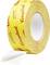 Rolka žltej lepiacej pásky značky „Coroplast" s červeným textom, čiastočne rozvinutá so zobrazením bielej lepkavej strany.