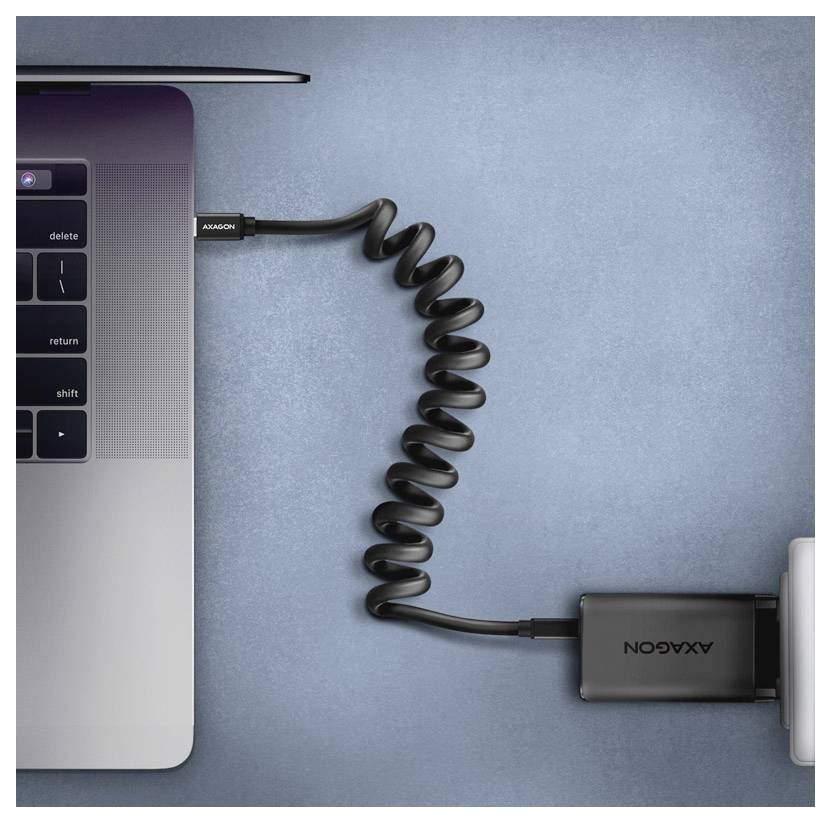 Ľavý horný roh laptopa pripojený k zvitému čiernemu káblu a adaptéru na modrom pozadí.