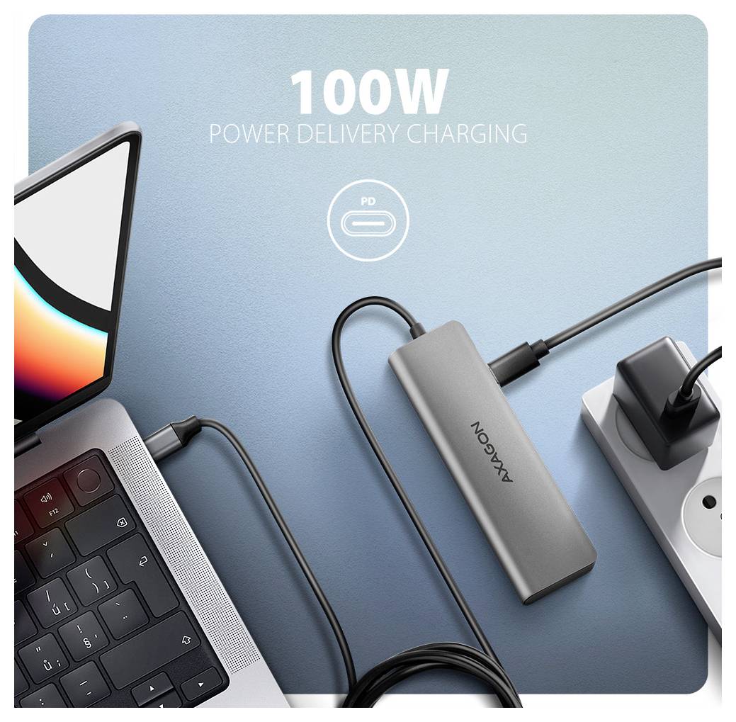 Propagačný obrázok notebooku pripojeného k USB-C hubu s textom „100W Power Delivery nabíjanie" a ikonou PD, ktorý zobrazuje viacero pripojených zariadení.