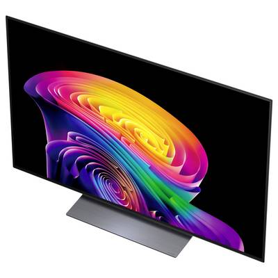 Plochý monitor s LCD obrazovkou zobrazujúci živú abstraktnú dúhovú špirálу na čiernom pozadí, zobrazený v uhle so strieborným stojanom.