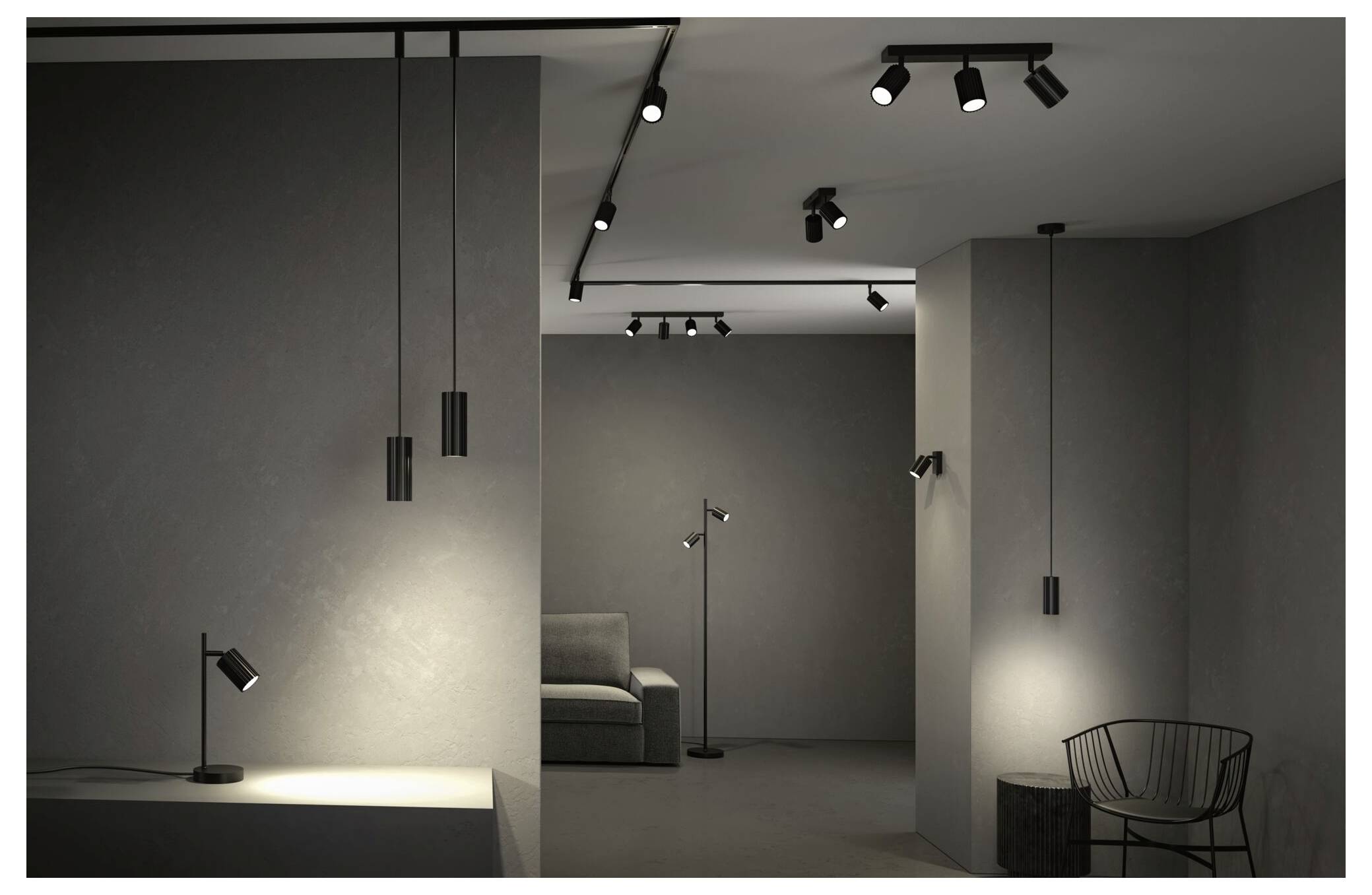 Minimalistický sivý interiér showroomu s stropnými koľajnicovými svetlami, nástenným osvetlením, pohovkou a drôtenou stoličkou