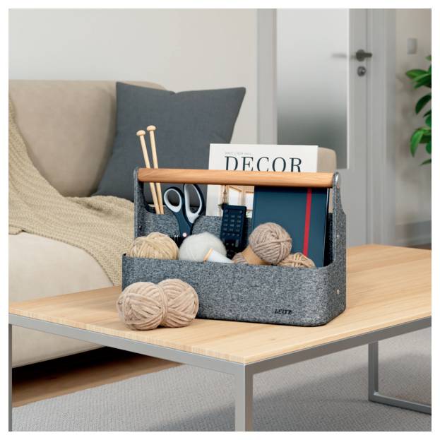 Sivá textilná organizérka na stolíku v obývacej izbe obsahuje pletacie potreby, nožnice, diaľkový ovládač a časopis „DECOR".