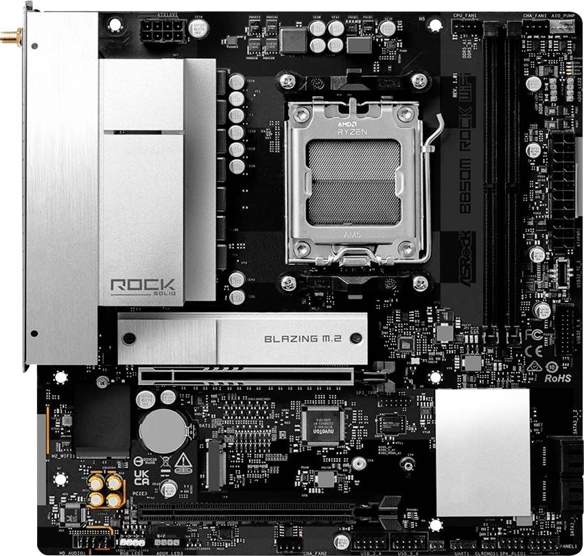 Pohľad zhora na matičnú dosku ASRock s nainštalovaným AMD Ryzen CPU, s viditeľnými strieborným chladičmi a krytom slotu M.2.