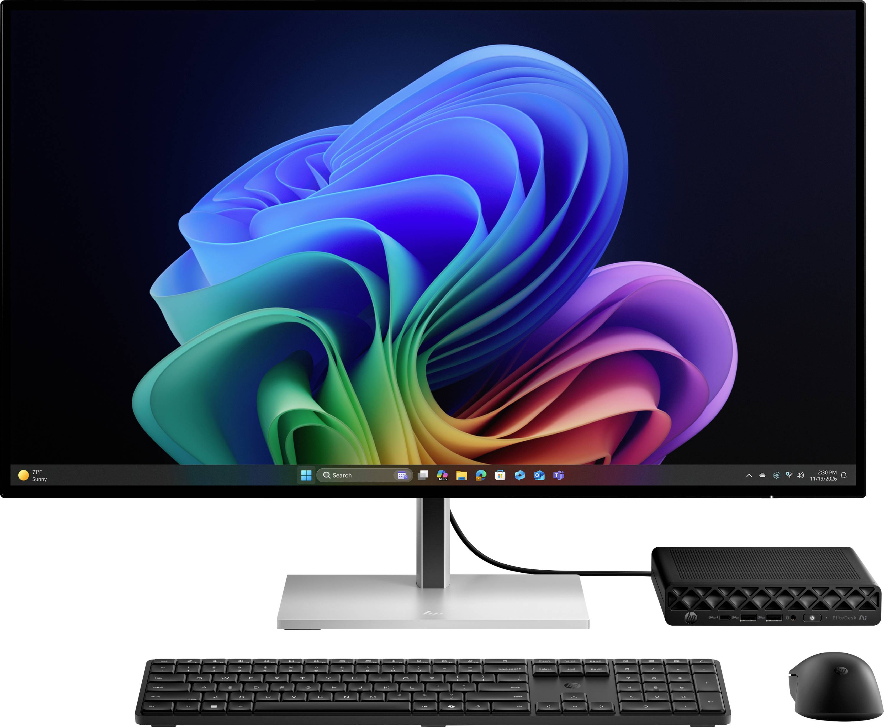 Nastavenie pracovného stola s monitorom zobrazujúcim tapetu Windows 11, klávesnicou, myšou a malou počítačovou vežou na bielom pozadí.