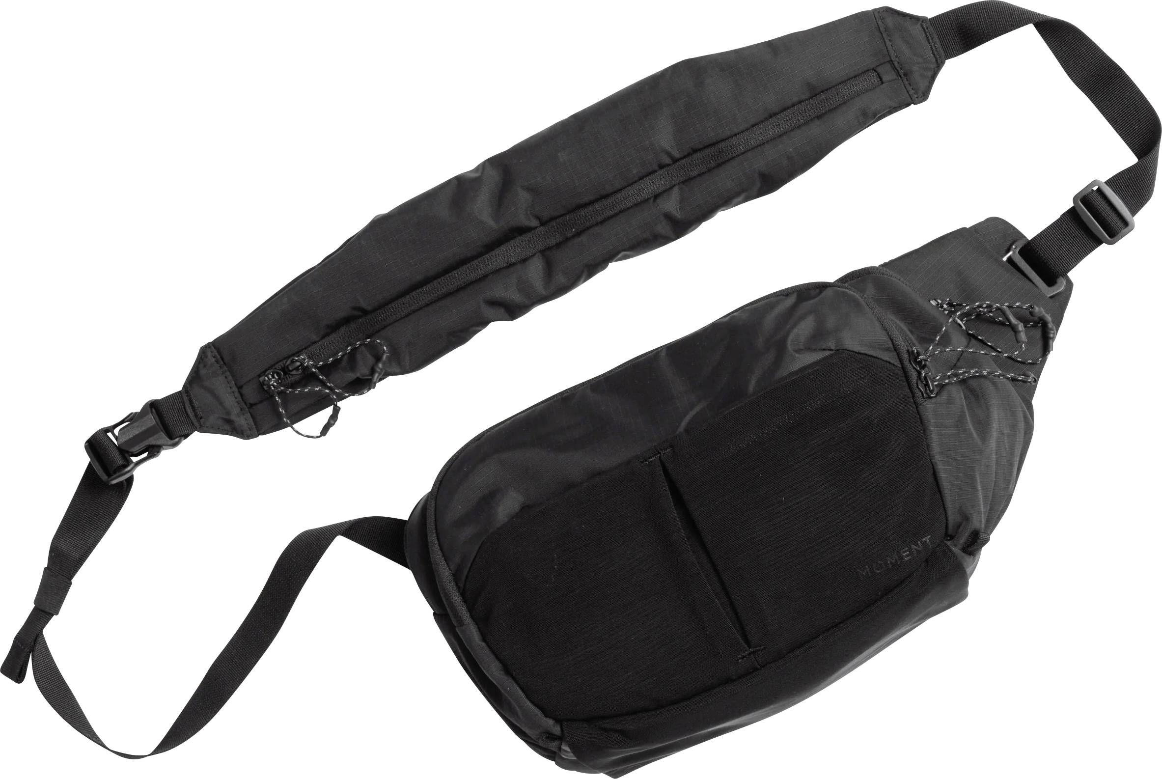 Čierna crossbody taška s nastaviteľným ramenom a mäkkým chrániacim obalom na ramene, zobrazená na bielom pozadí.
