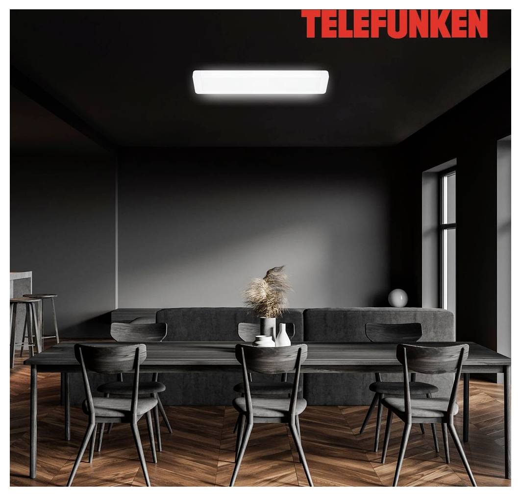 Tmavá moderna jedáleň s logom TELEFUNKEN, s dlhým stolom, šiestimi stoličkami, sivou pohovkou, závesným svetlom a parkety s vláknistým vzorom.