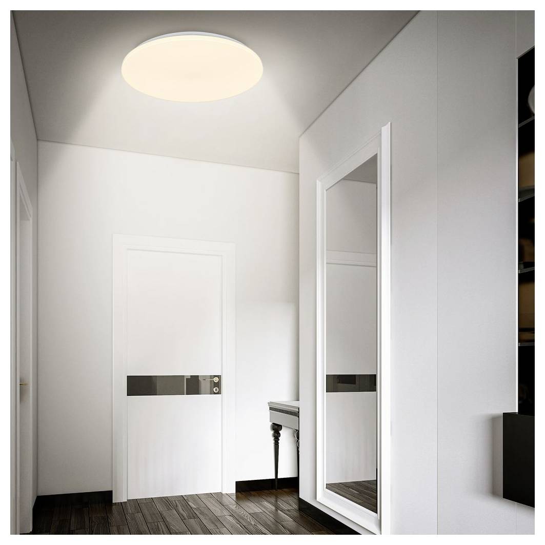 Minimalistická biela chodba so dverami, zrkadlom v plnej dĺžke, malým stolíkom a stropným svetlom, zobrazená s tmavými drevenými podlahami a čistými modernými povrchmi.