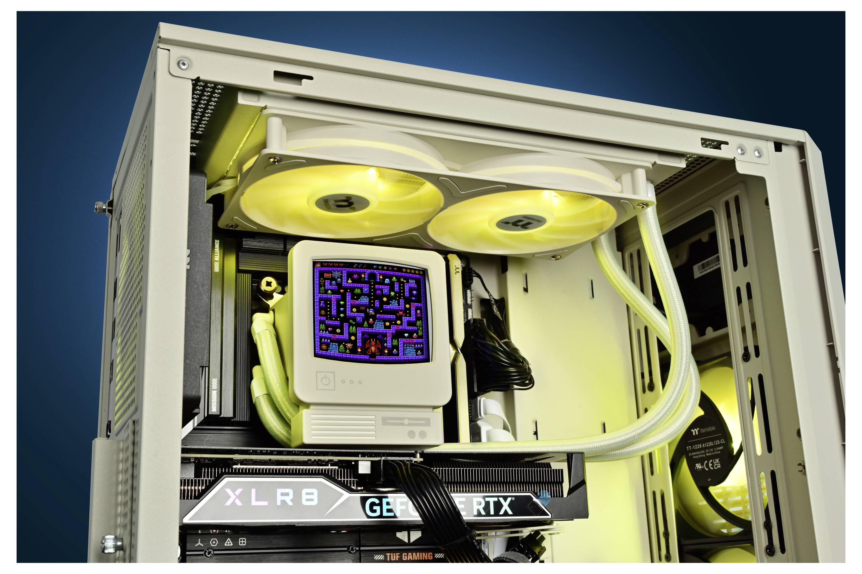 Otvára sa PC skrinka na pracovnom stole s jazykovou chladiacou hernou sústavou so žiarivými ventilátorikmi a grafickou kartou GeForce RTX, plus malý displej v štýle PAC-MAN vo vnútri.