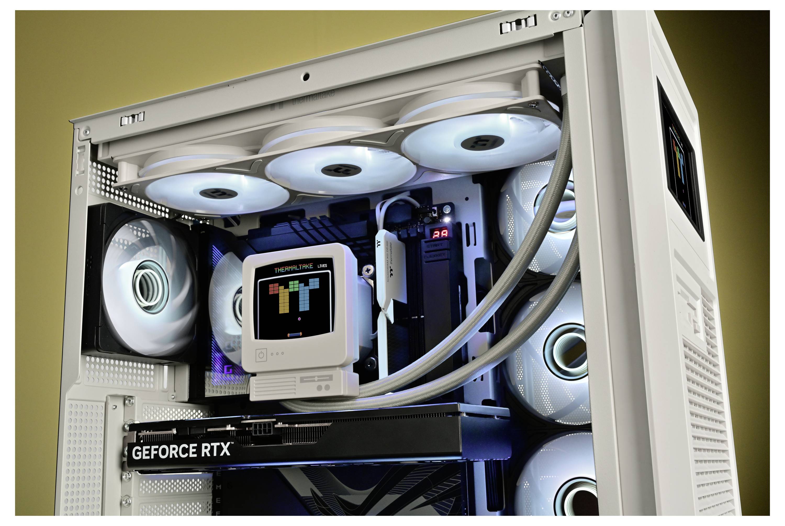 Otvorená biela skrinka stolného počítača s osvetlenými chladiacimi ventilátorikmi a grafickou kartou GeForce RTX vo vnútri.