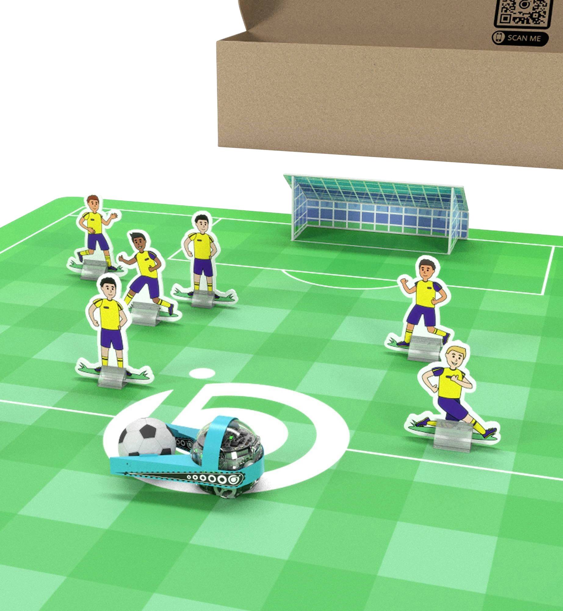 Scéna s hračkami na futbal s piatimi papierovými figurkami hráčov, malou bránkou a modrým robotom na zelenom ihrisku vedľa kartónovej krabice označenej „SCAN ME".