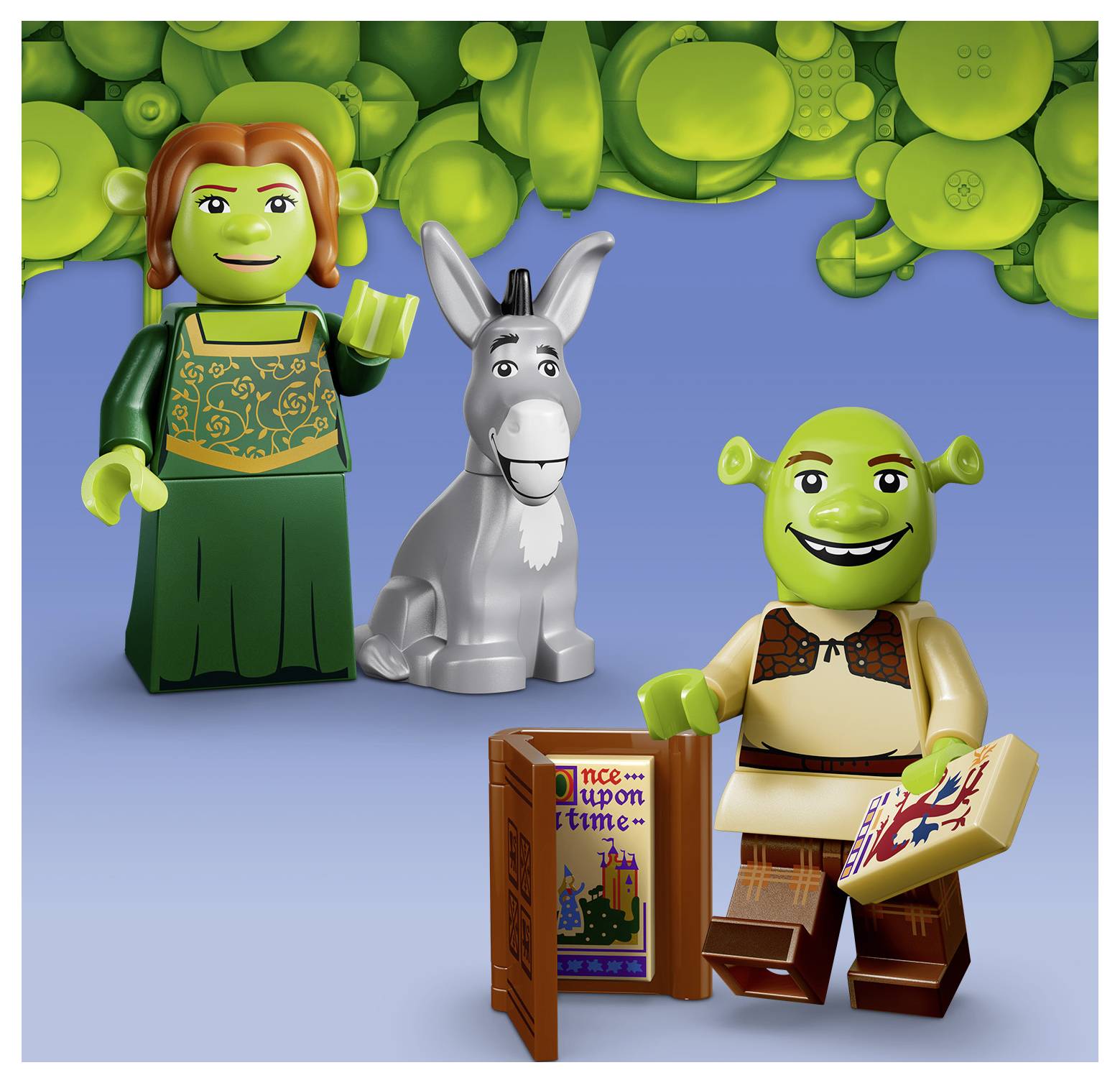 LEGO-štýlové postavy Shreka: Princezná Fiona stojí vedľa Osla a Shreka s otvorená knihou a „Kedysi davno" rozprávkou na modrom pozadí.