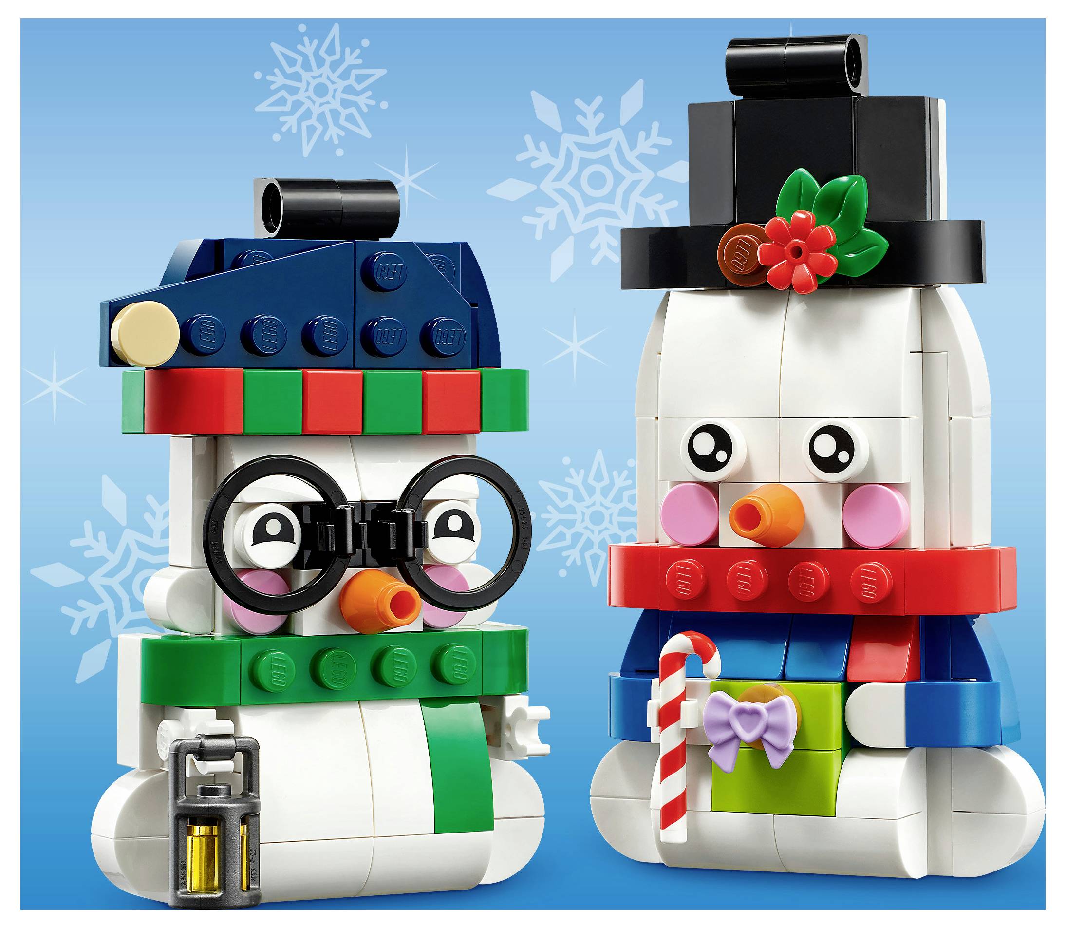 Dve postavy LEGO snehuliaka, jedna s okuliariami a lampášom, druhá s cylindrom a cukríkovou palicou, postávajúce sa pred snežným modrým pozadím.