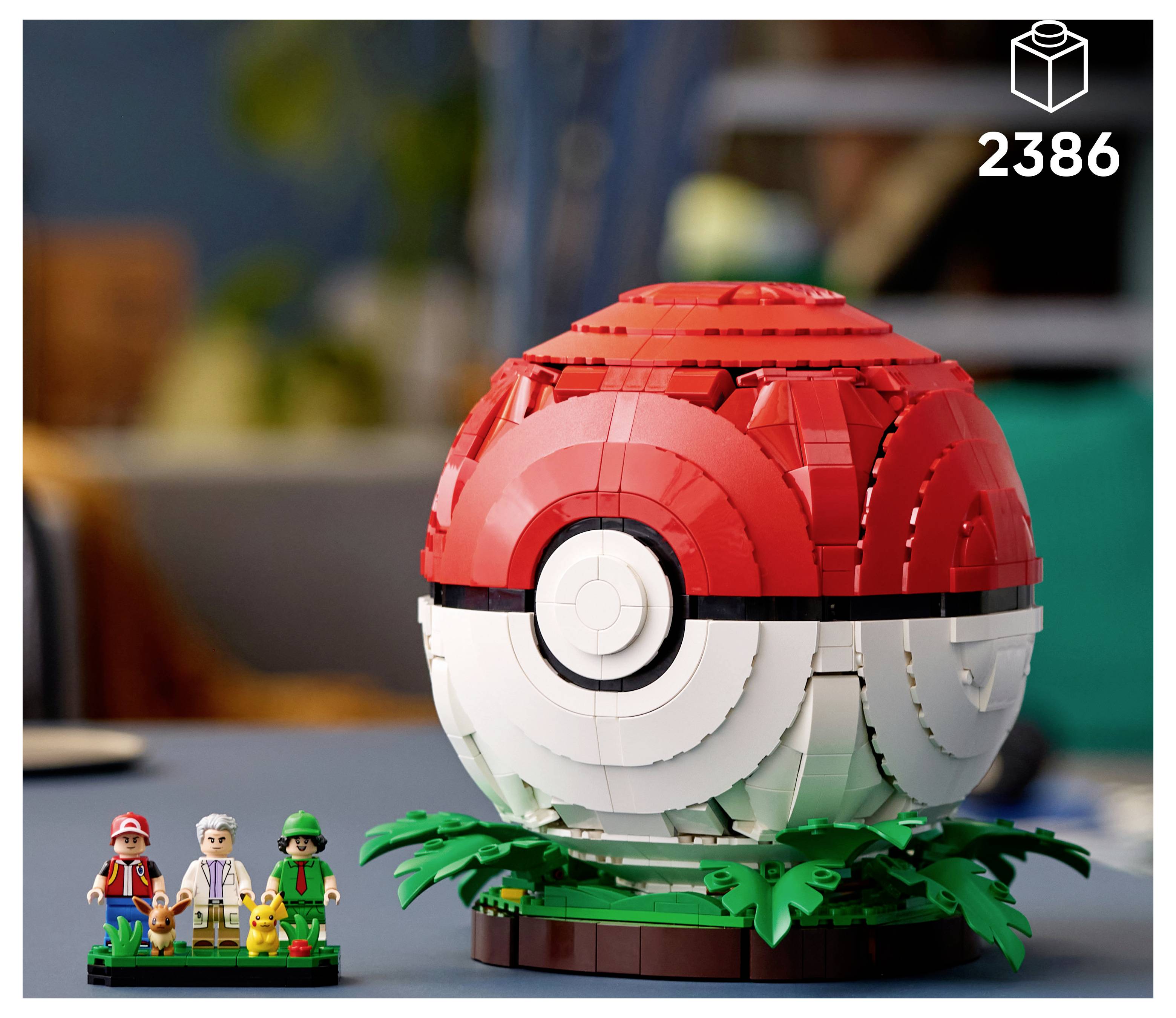 LEGO Poké Ball na stojane na vystavenie, s tromi minifigúrkami a malým modelom Pikachu v popredí; číslo sady 2386 zobrazené v pravom hornom rohu.