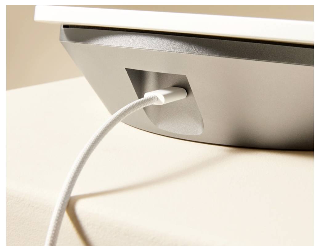 Zväčšený záber na monitor alebo zariadenie s bielym kabelom zastrčeným do zapusteného portu na zadnej strane.