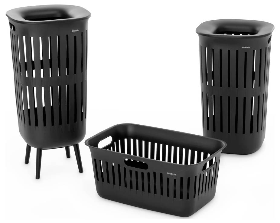 Tri čierne práčové koše s otvormi, vrátane dvoch vysokých košov na bielizeň v štýle hamper a jedného nízkeho obdĺžnikového košíka, zobrazené na bielom pozadí.
