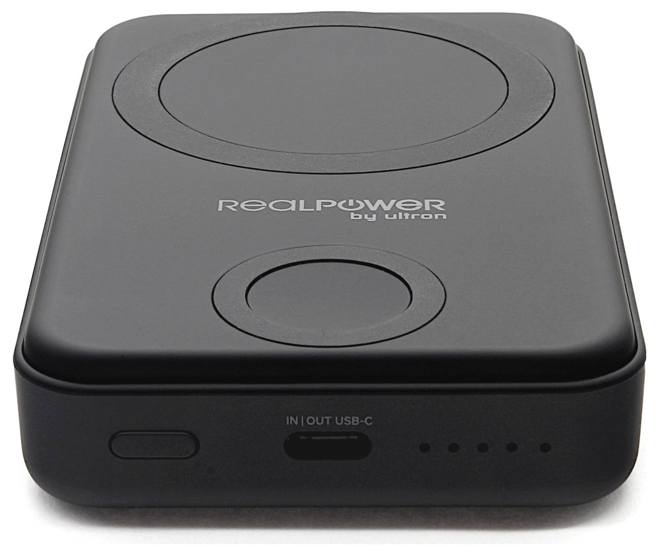 Čierna prenosná powerbanка RealPower od Ultron s bezdrôtovým nabíjacím podložkou, portom USB-C a indikačnými svetlami batérie.