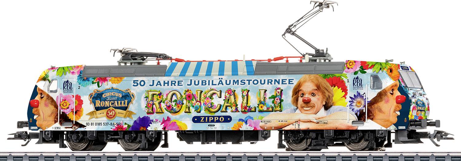 Farebná elektrická lokomotíva s kvetinovou farbou "Roncali" k výročiu, textom "50 Jahre Jubiläumstournee" a portrétom psa na boku.