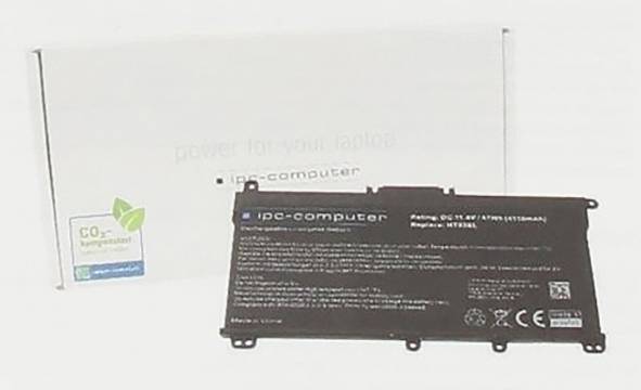 Batériový pack notebooku označený „ipc-computer" so zelenou kartou „CO2 kompensiert" a dvoma kovovými tyčami v pozadí.
