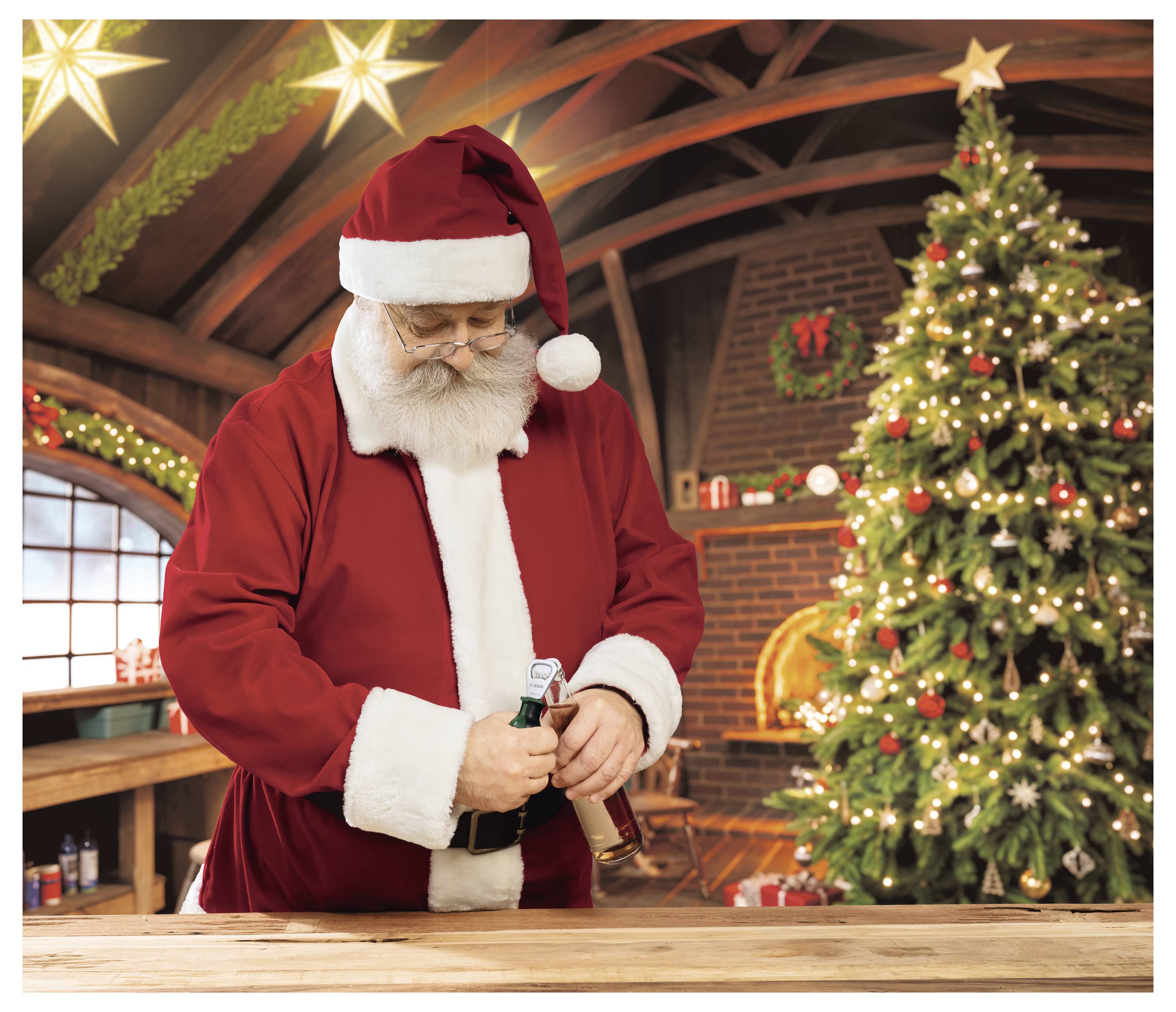 Dedko Mráz v červenom obleku otvára fľašu pri slávnostnej vianočnej scéne s vyzdobeným stromčekom a krbom.