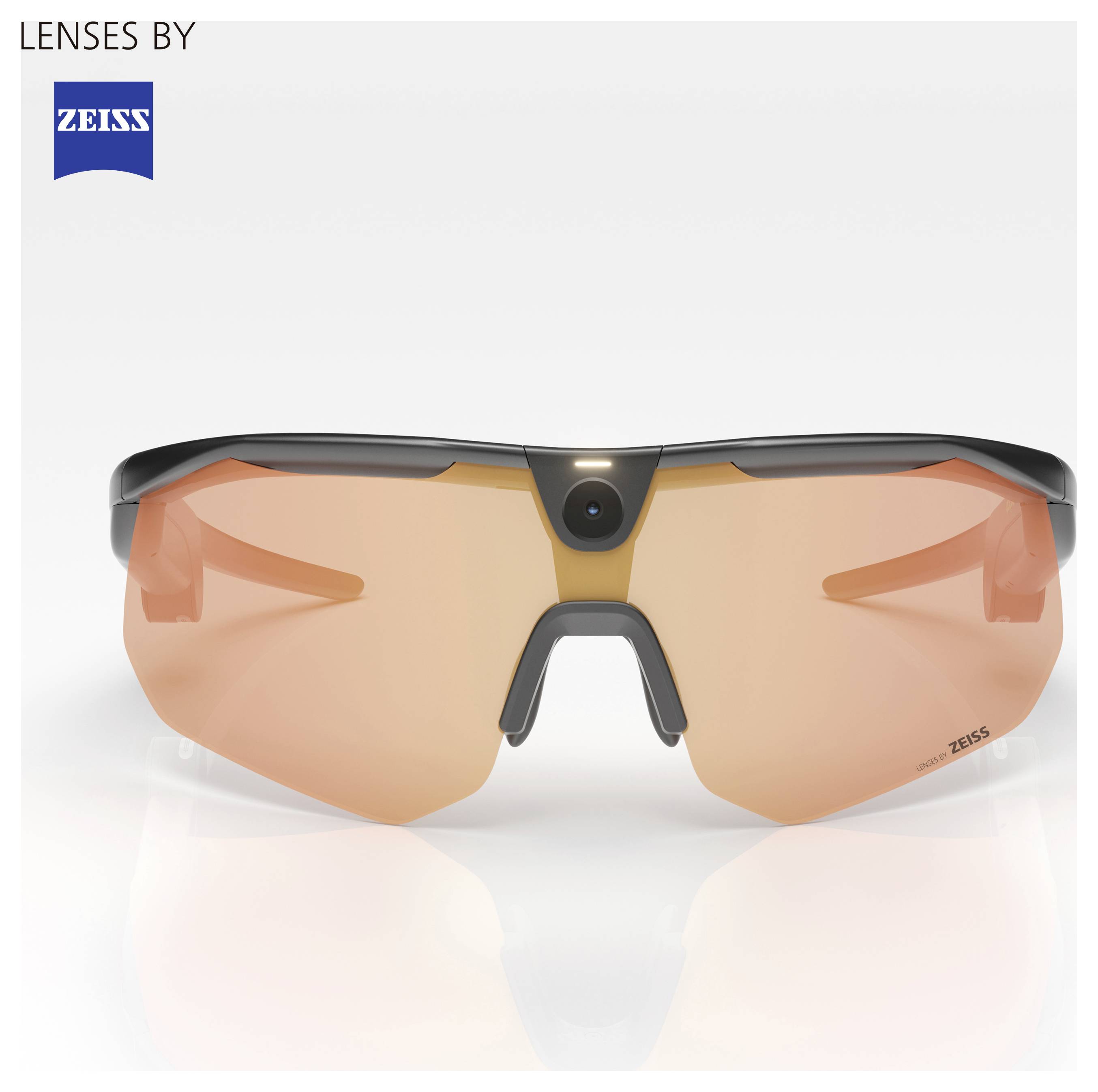 Okuliare ZEISS na šport s oranžovo tintovanými ovinutými šošovkami a centrálnym mostíkom na nose, zobrazené na bielom pozadí s značkou „LENSES BY ZEISS".