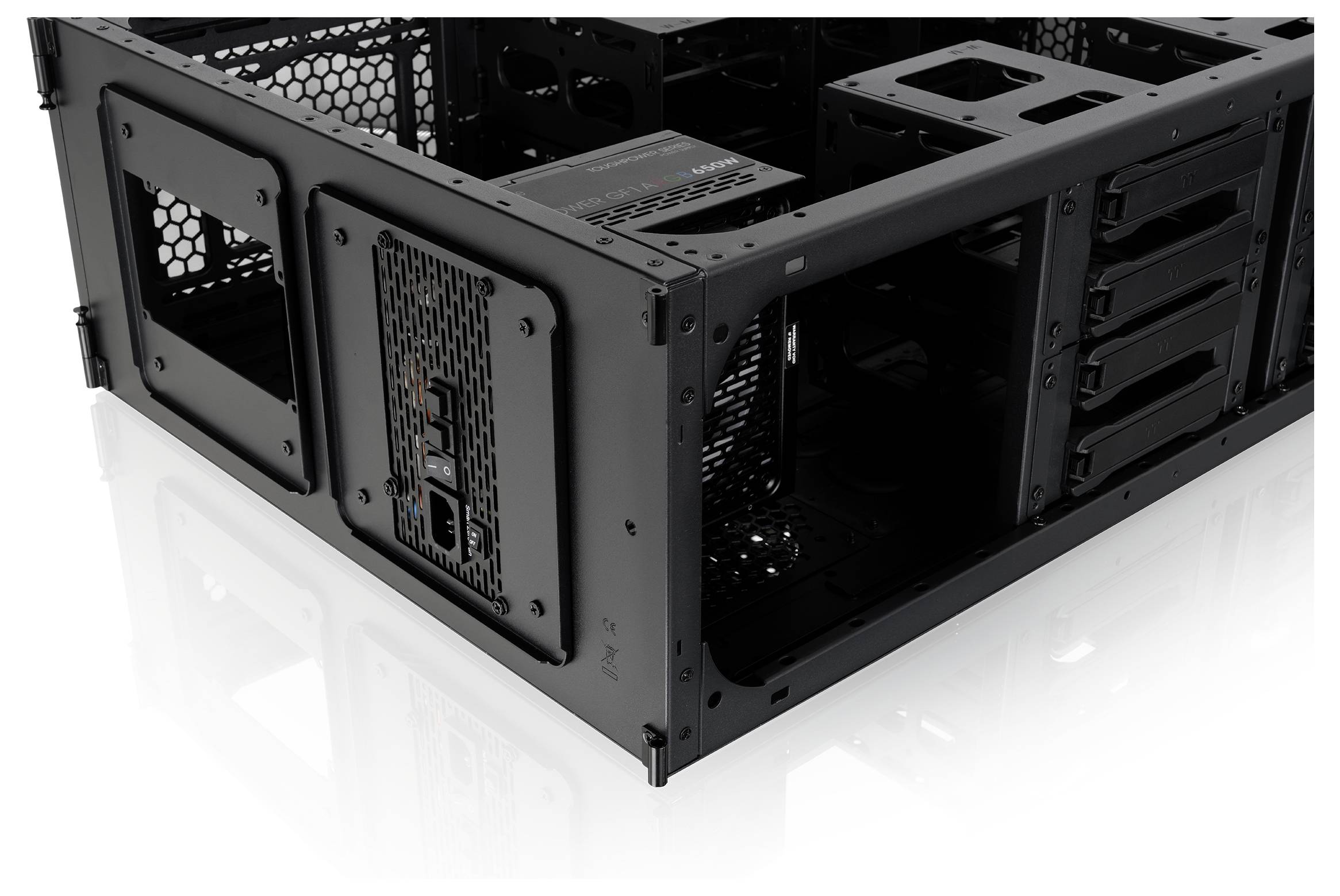 Otvorená čierna počítačová skriňa so zobrazením na bielom pozadí, s viditeľnými jednotkami na disky, sieťovanými panelmi a oblasťou na montáž základnej dosky.