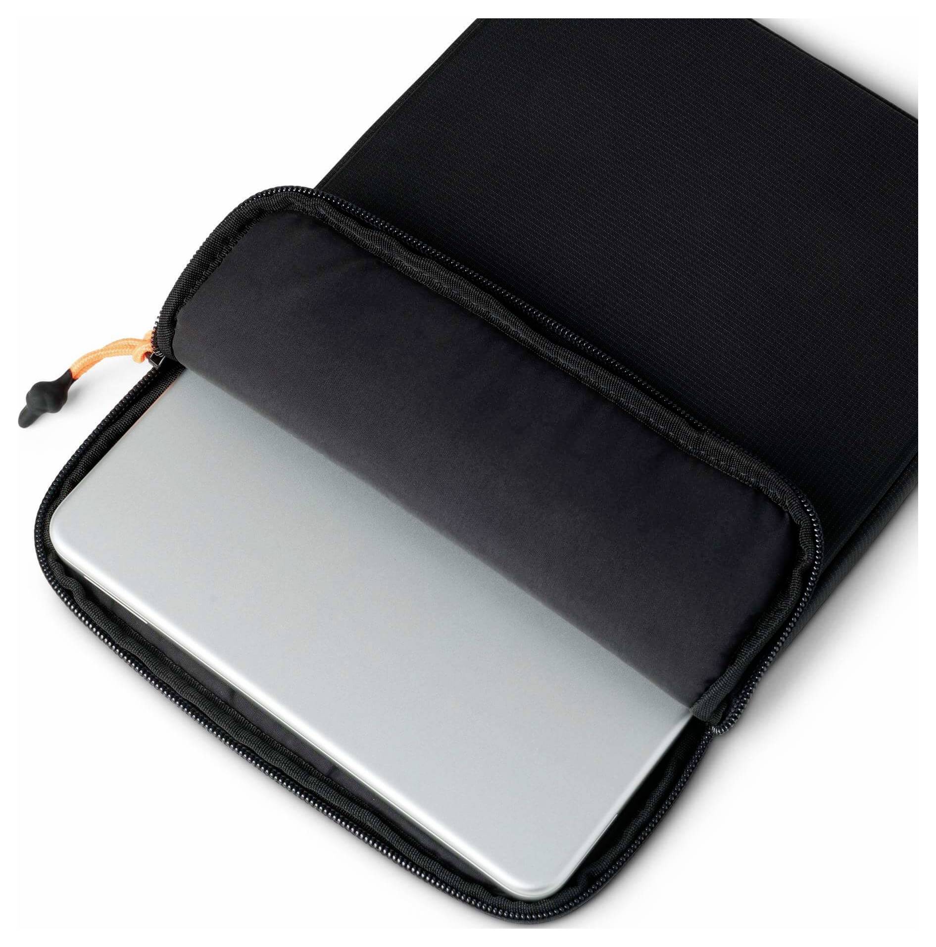 Strieborný laptop čiastočne vložený do čierneho zipsového obalu na nosenie na bielom pozadí.