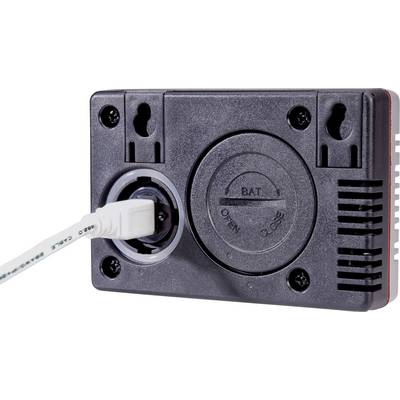 Čierne elektrické zariadenie s pripojeným bielym káblom. Na kruhovom kryte batérie sú vyznačené nápisy 'Open' a 'Close'.