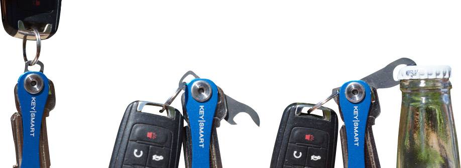 Kľúčenka 'KeySmart' s otváračom na fľaše na autokľúčoch. Uzáver fľaše sa otvára.