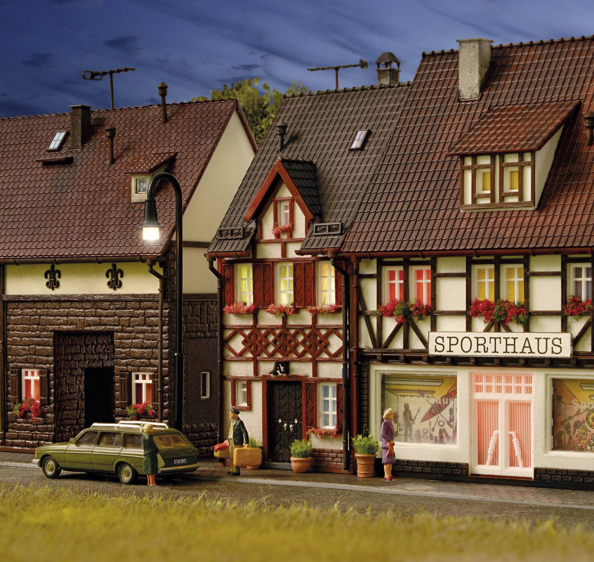 Miniaturový model ulice s hrázdenými domami. Jedna z budov je 'Sporthaus', pred ňou stojí starý zelený kombi.