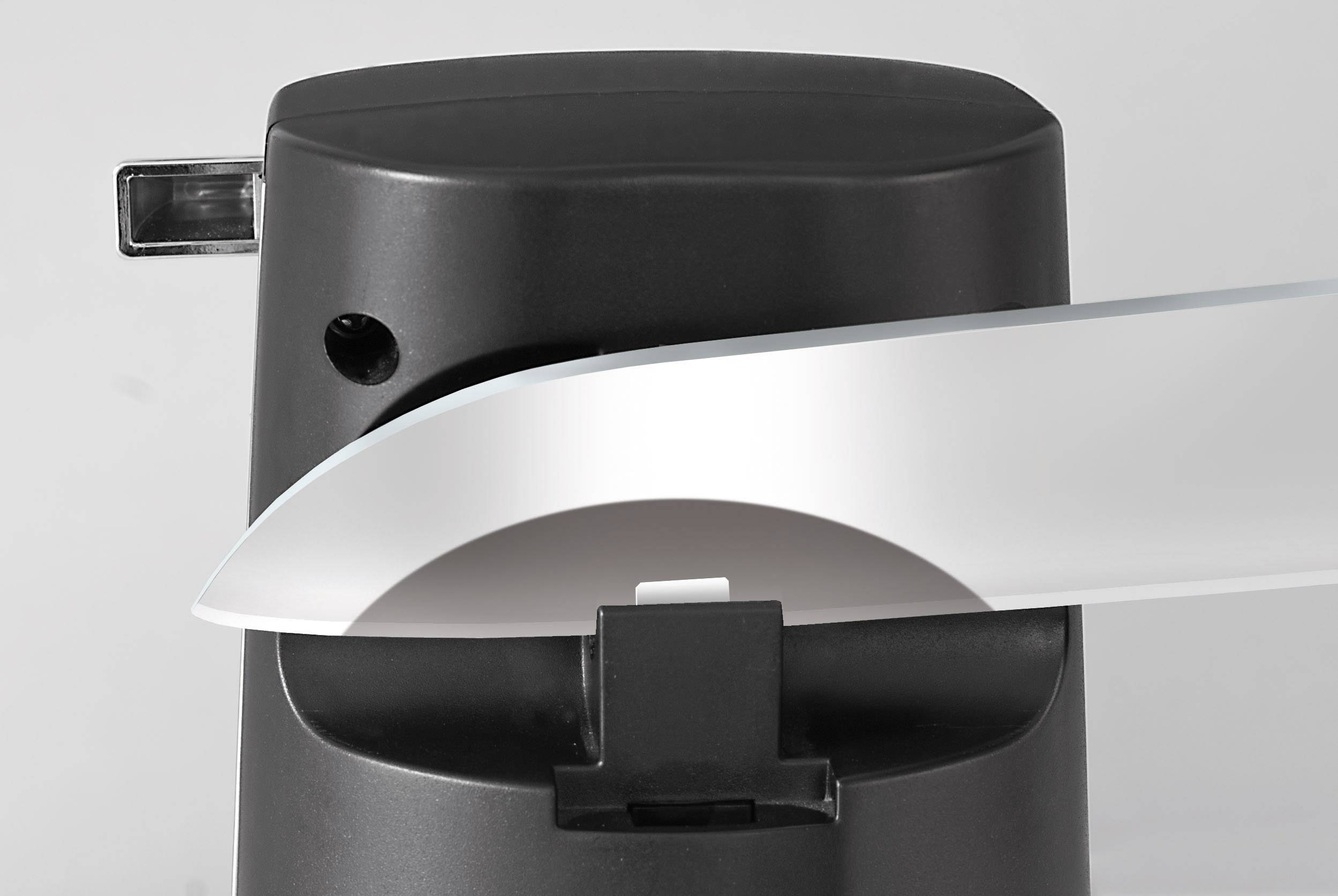 Elektrická brúska na nože s nožom, ktorý je vedený cez brúsny mechanizmus za účelom naostenia čepele.