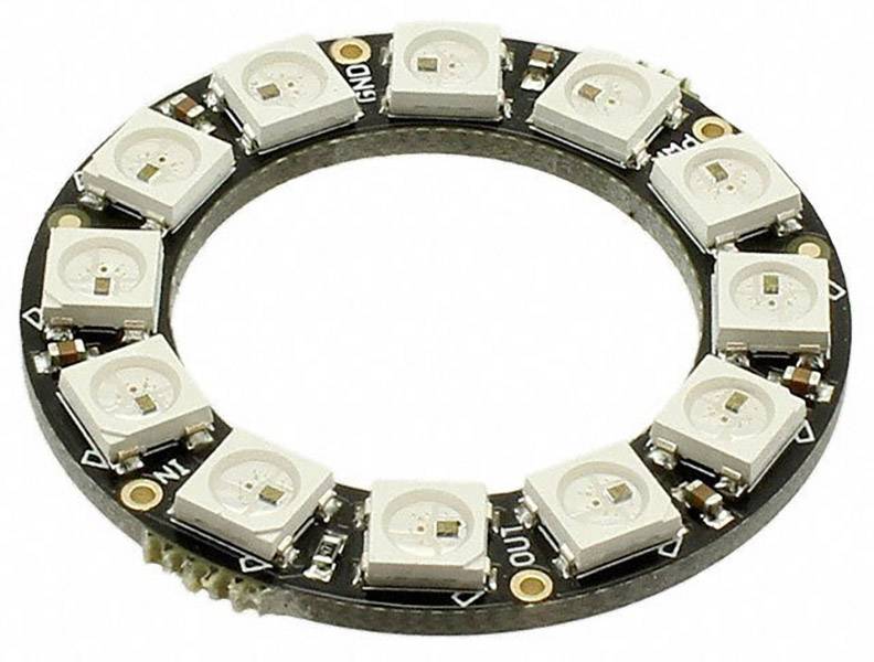 Guľatý LED prsteň s 12 individuálne adresovateľnými RGB LED diódami na čiernej doske plošných spojov. Vhodný pre osvetľovacie projekty.