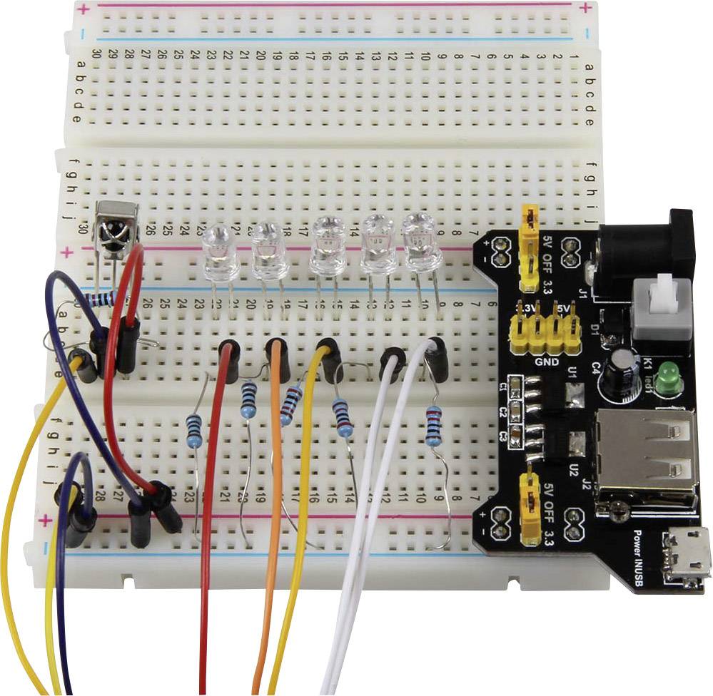 Nepájacia doska s elektronickými komponentmi a LED diódami. Viaceré vodiče spájajú súčiastky pre ukážku elektrického obvodu.