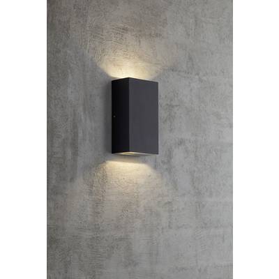 Nástenná lampa s obdĺžnikovým, čiernym krytom na sivej betónovej stene. Svetlo sála smerom nahor a nadol pozdĺž steny.