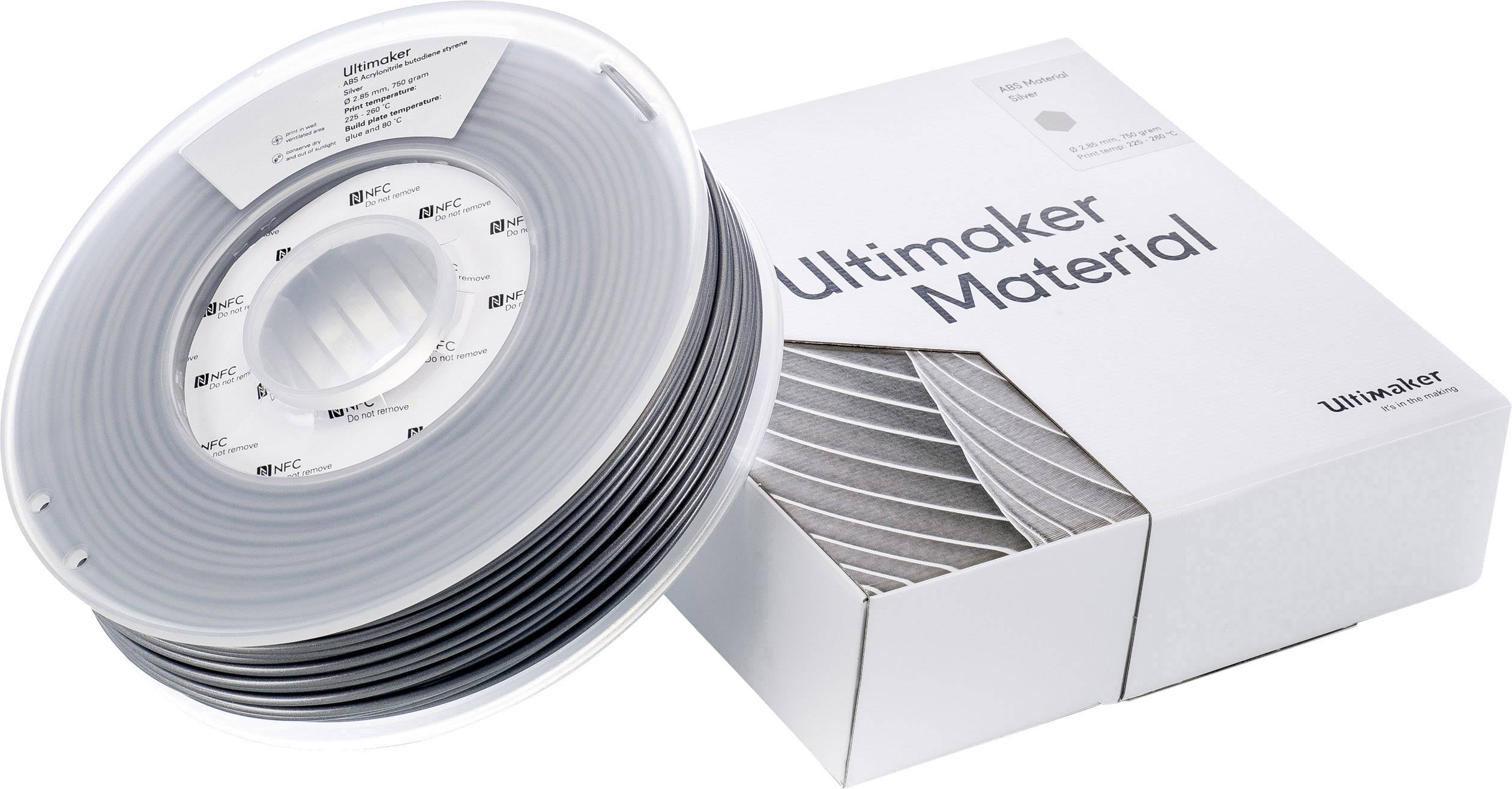 Špulka čierneho 3D tlačiarenského filamentu vedľa bielej škatule s nápisom 'Ultimaker Material'.