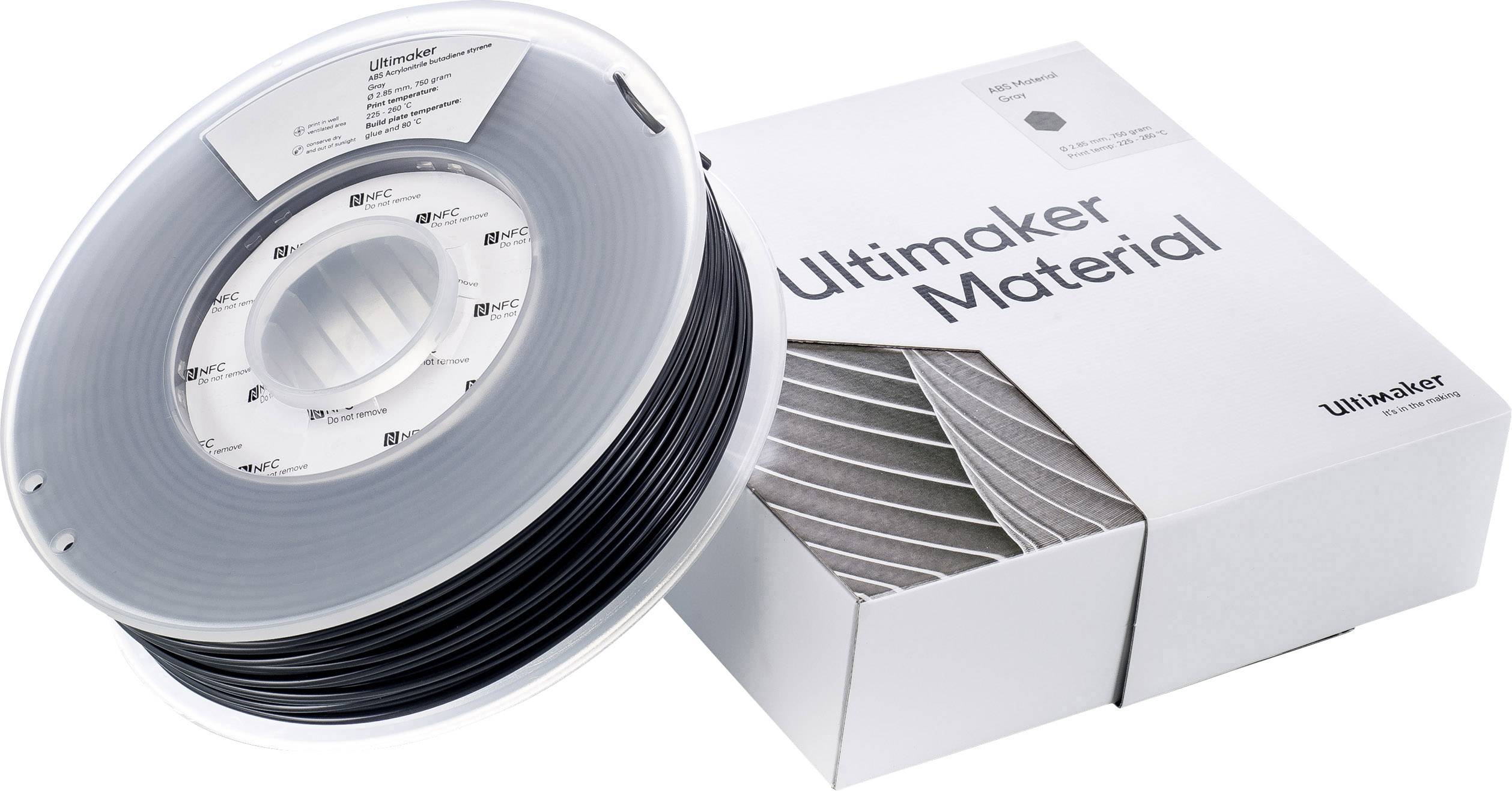 Rolka čierneho 3D tlačiarenského filamentu vedľa bielej krabice s nápisom "Ultimaker Material".