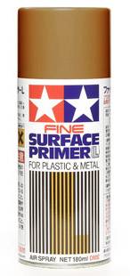 Sprej základného náteru 'Fine Surface Primer L' v hnedej farbe, vhodný pre plast a kov, s objemom 180 ml. Obal je dizajnovaný so štruktúrou pruhov a obsahuje názov značky.
