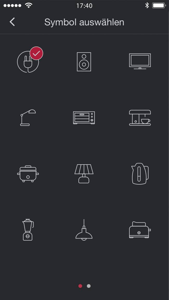 Obrazovka „Vybrať symbol" s dvanástimi symbolmi pre rôzne domáce spotrebiče vrátane lampy, reproduktora, televízora, kávovaru a tosteru. Jeden symbol je vybratý.