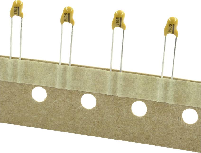 Štyri žlté kondenzátory na páske s otvormi pre strojové osádzanie v elektronickej výrobe.