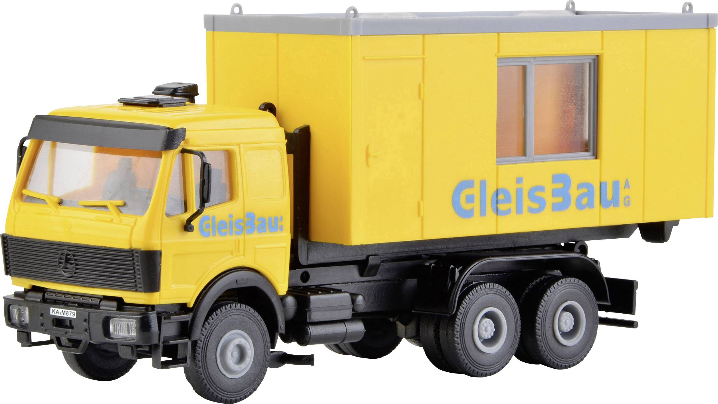 Žltý hračkársky nákladný automobil s nápisom 'GleisBau AG' na boku žltého kontajnera. Nákladiak má čiernu kabínu vodiča.